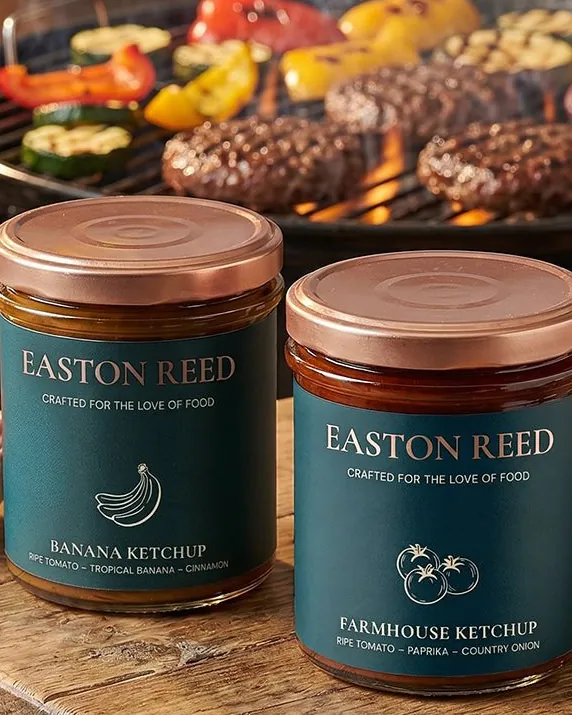 Easton Reed Banana and Farmhouse Ketchup jars in front of a barbecue grill
